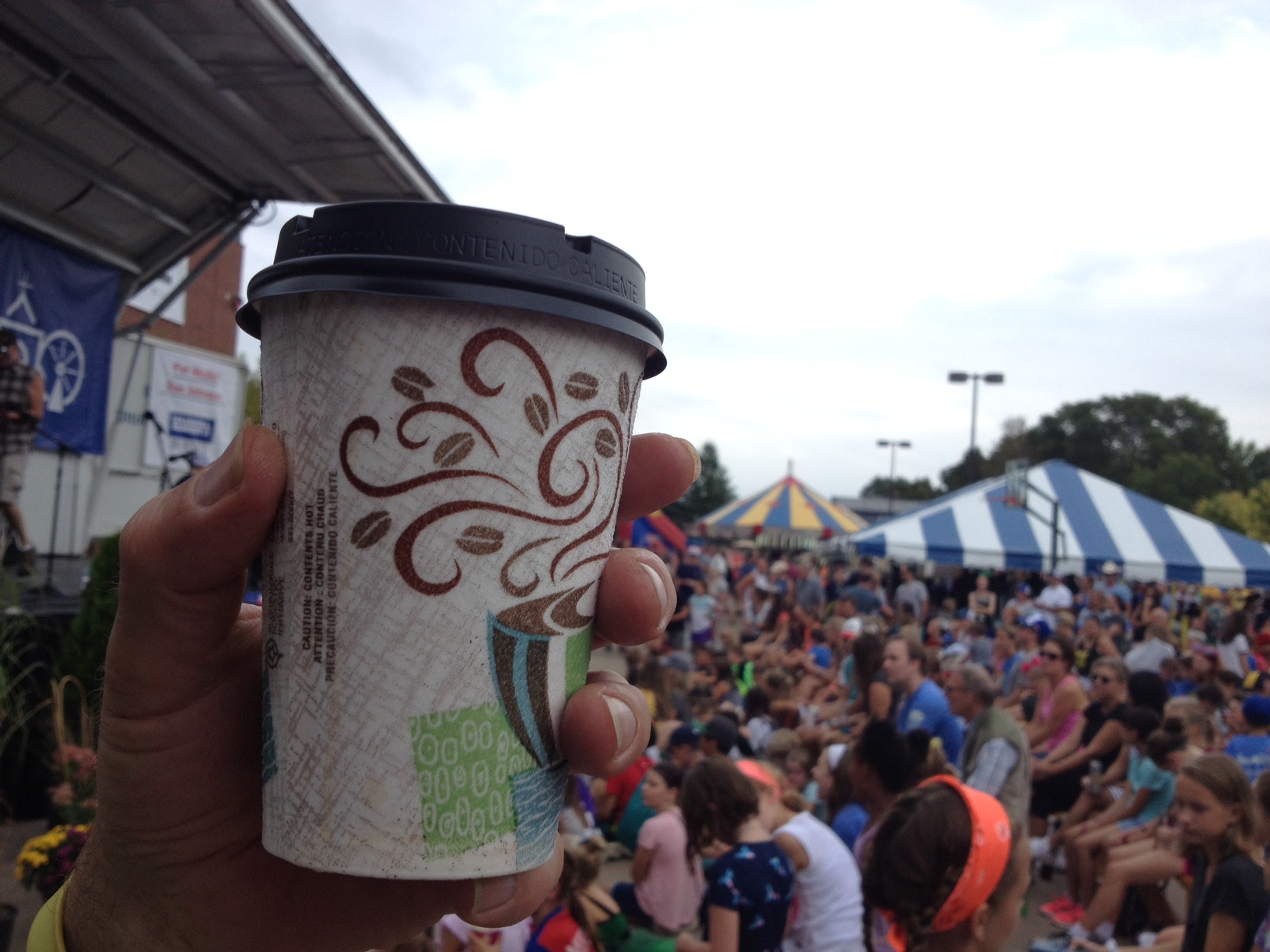 Photo showing a delicious cup of hot, decaf coffee with the fair in the background